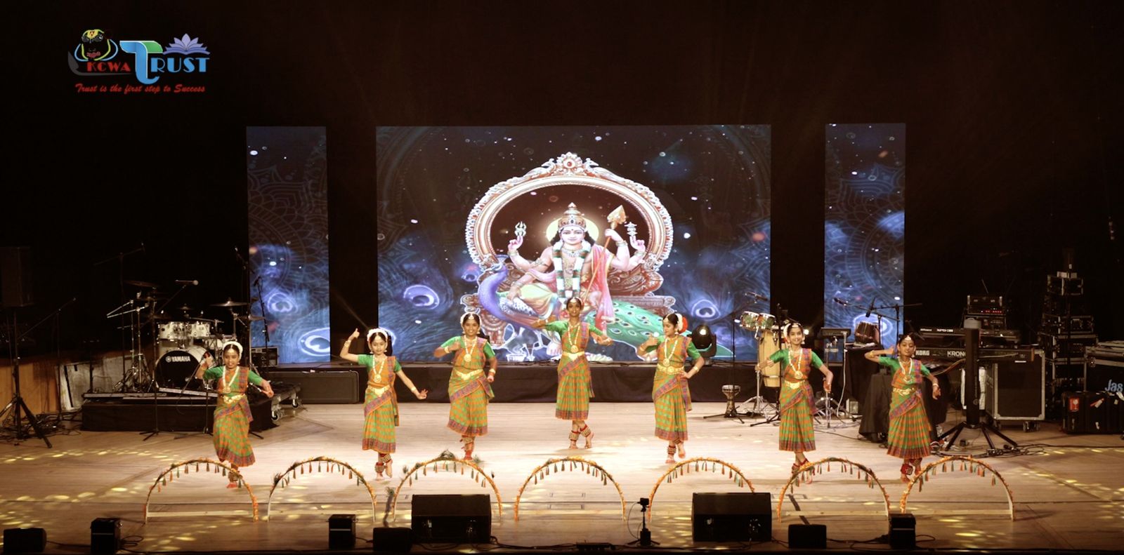 Performers on stage with a temple backdrop on the LED wall
