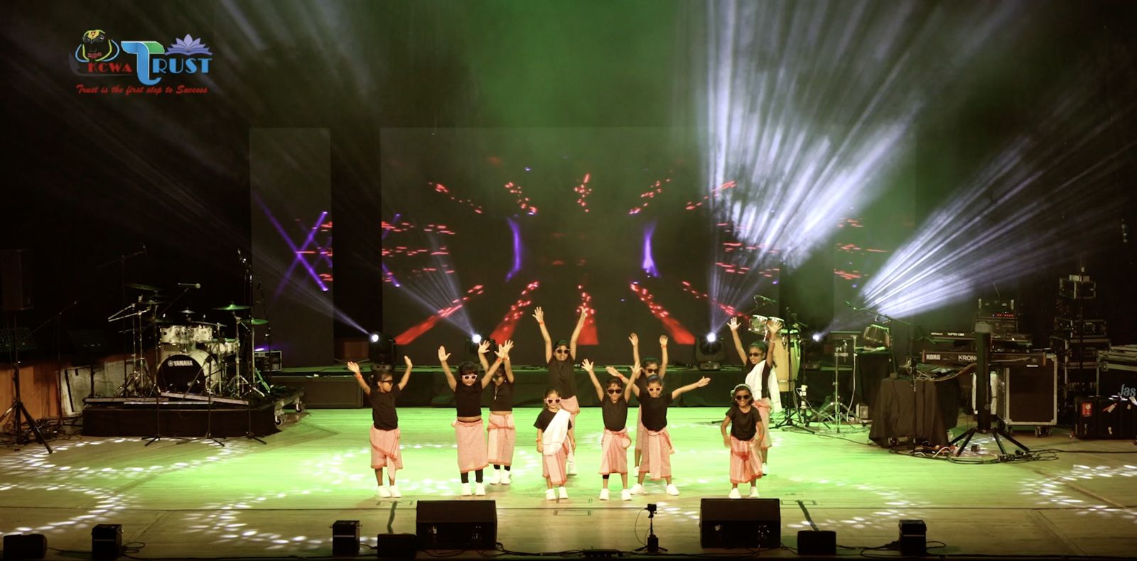 Dancers on stage in front of the LED wall, lit in purple